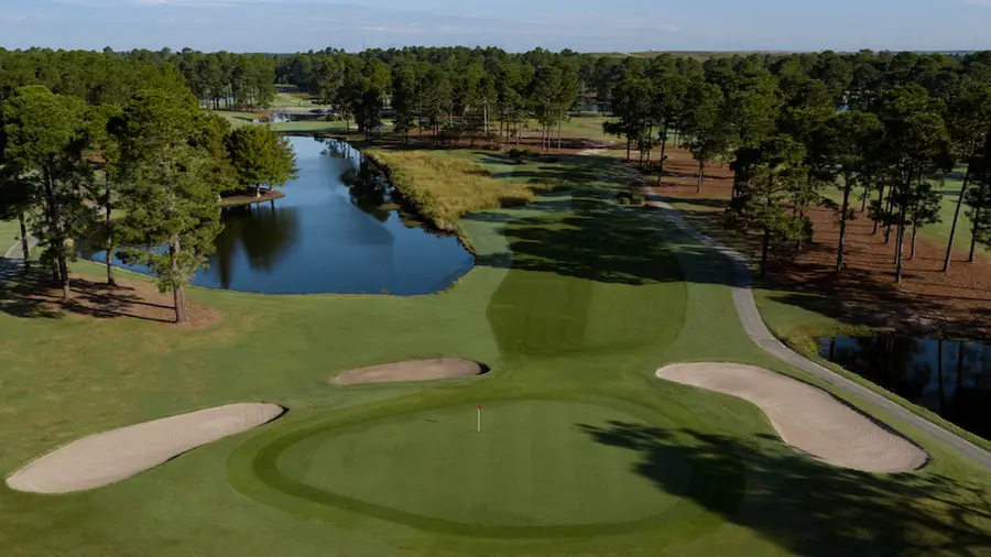 Aerial view of a green on the West Course at Myrtle Beach National with bunkers on both sides and a lake behind