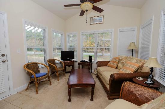 Living area of a Barefoot condo with a screened door onto the porch