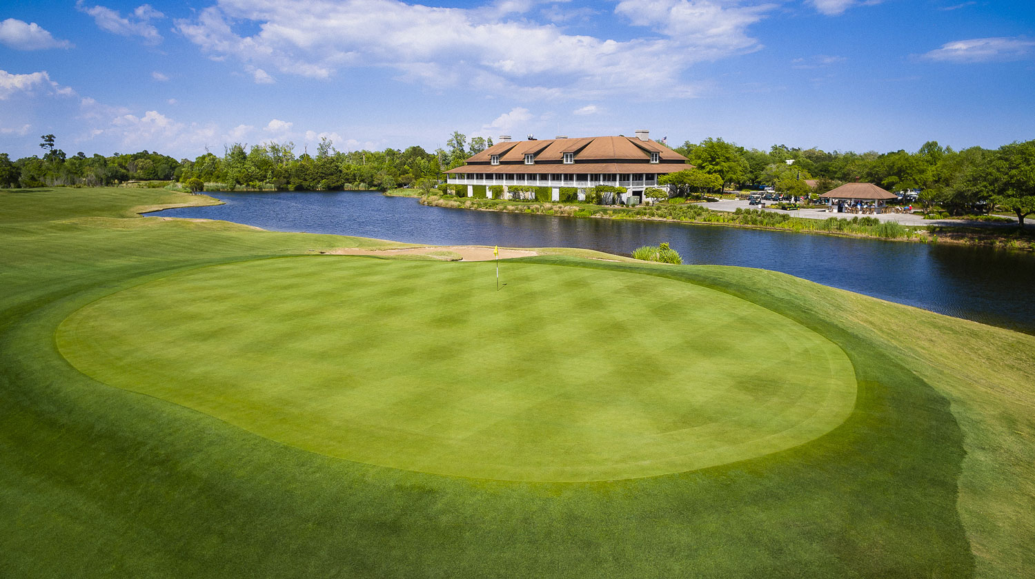 The Barefoot Resort clubhouse across the water from a finishing green