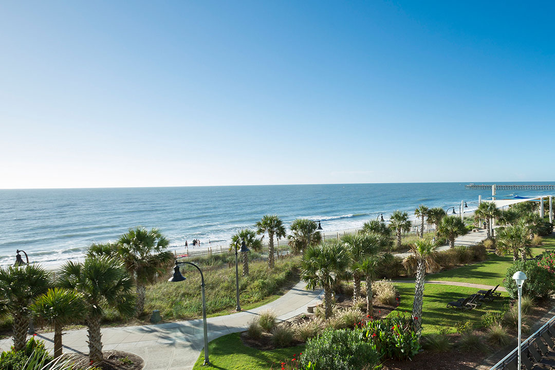 The ocean and the boardwalk gardens seen from Bay View Resort, with the pier in the distance