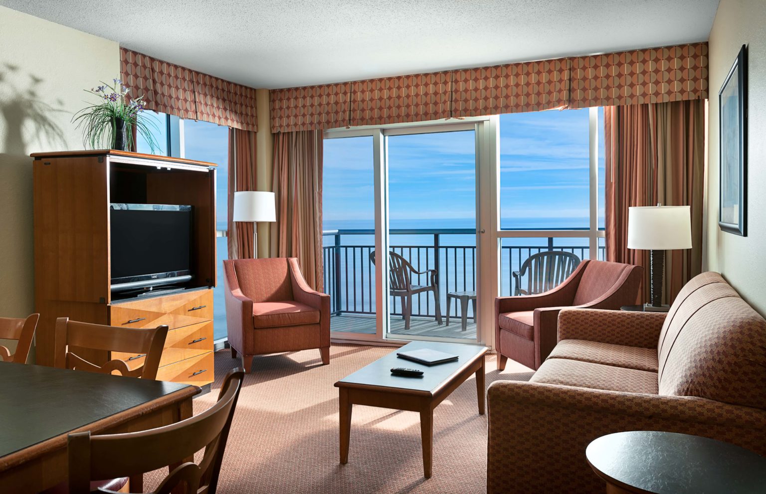 Living area of an oceanfront condo at Bay View Resort, with a balcony over the water