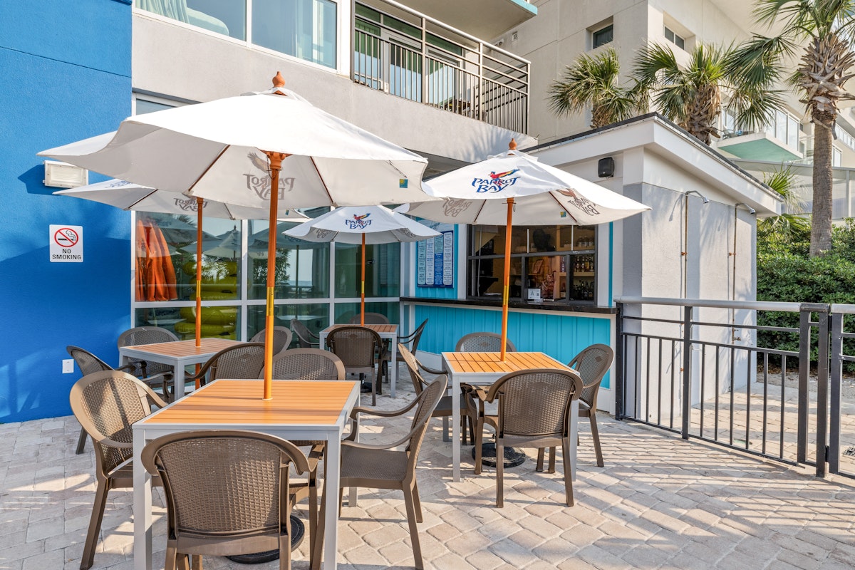 The oceanfront pool bar and shaded patio tables at Bay View Resort