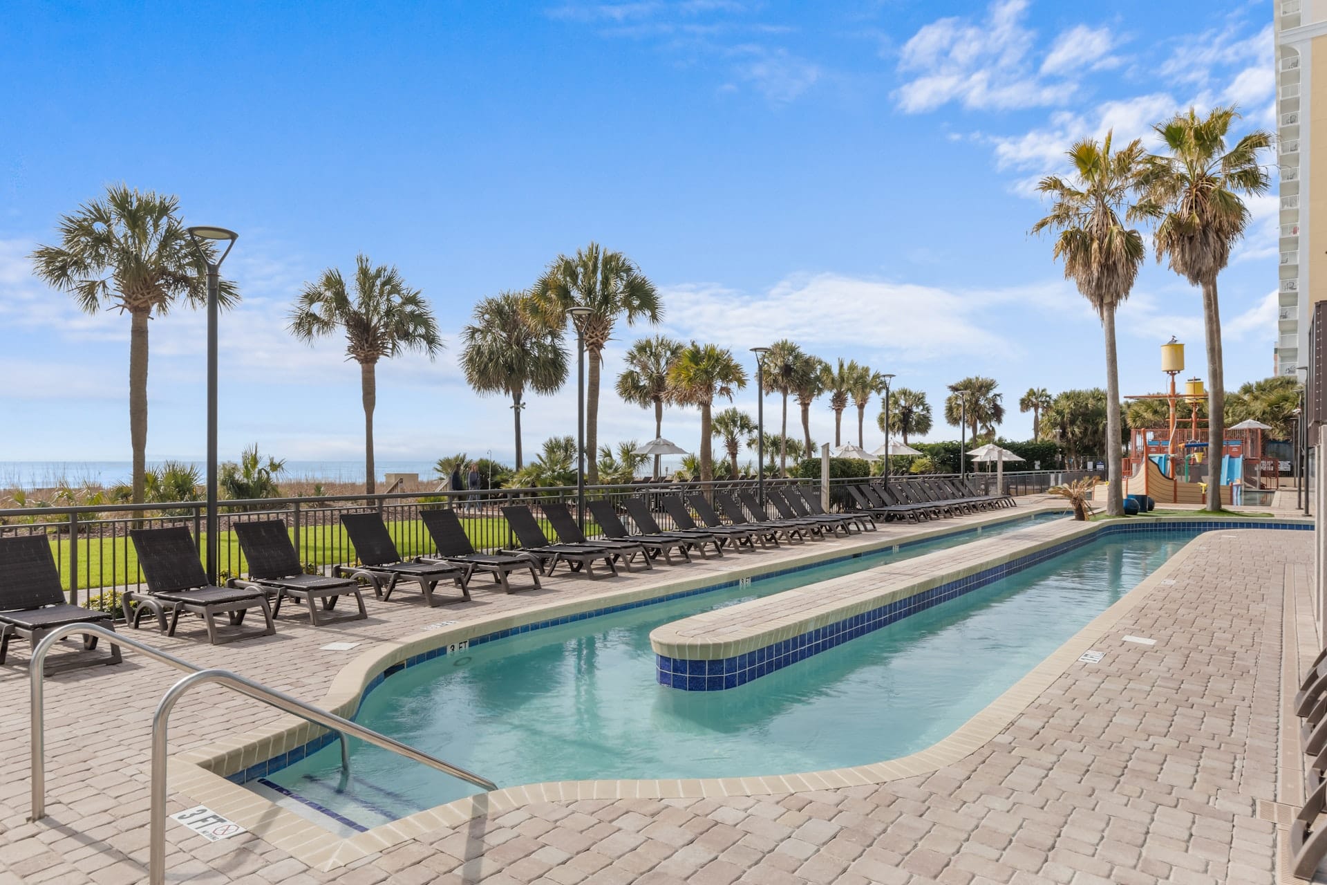 The oceanfront outdoor pool and sun loungers at Breakers Resort