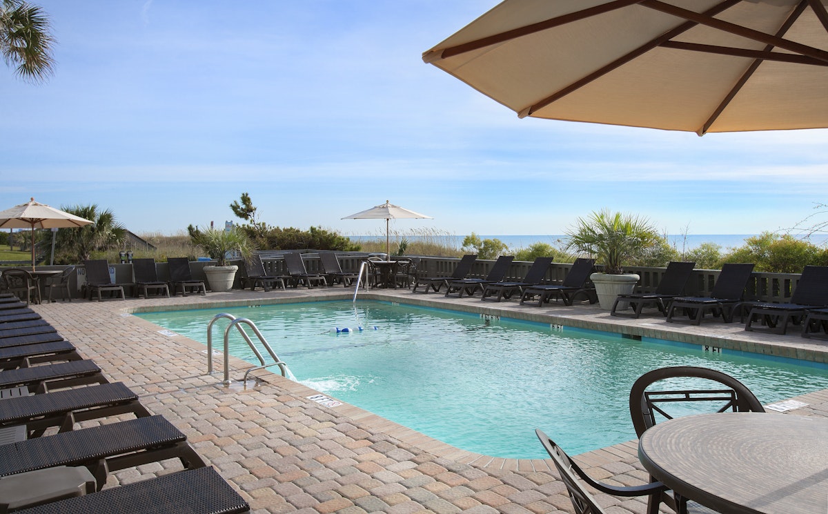 The oceanfront pool and sun loungers looking out to the water at Caribbean Resort and Villas