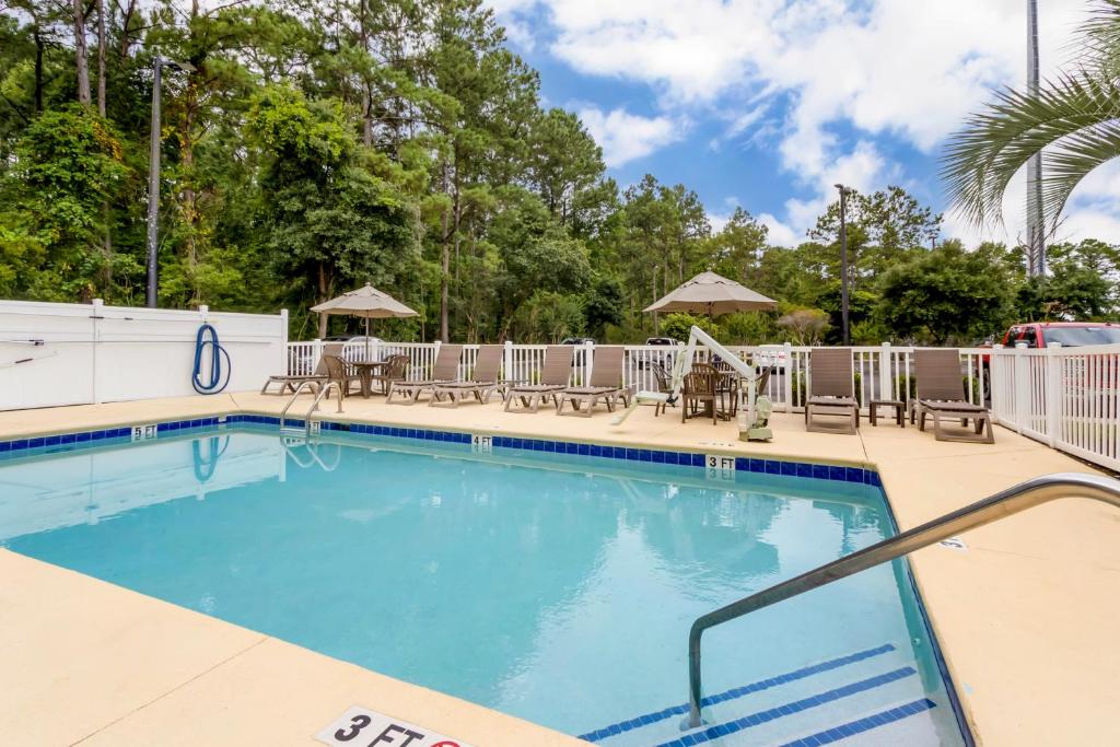 The outdoor pool, loungers and umbrellas at Comfort Suites at the University