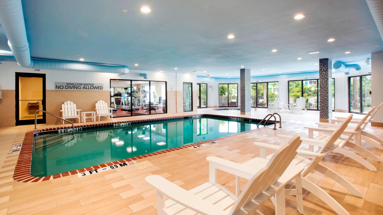 The indoor pool and hot tub beside the fitness room at the Courtyard by Marriott