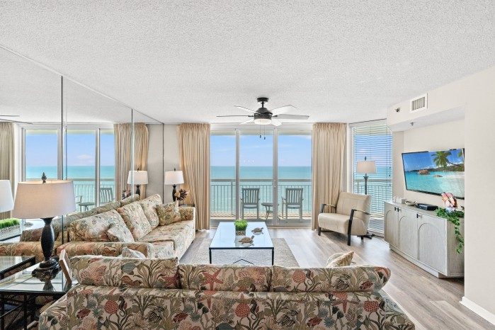 Living area of an oceanfront condo at Crescent Shores, with sliding doors onto the balcony