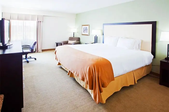 King guest room with a seating area, work desk and television