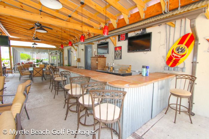 The covered outdoor bar and games area beside the pool at Legends