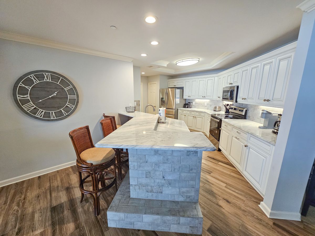 Condo kitchen at Margate Tower with a marble island and breakfast bar seating
