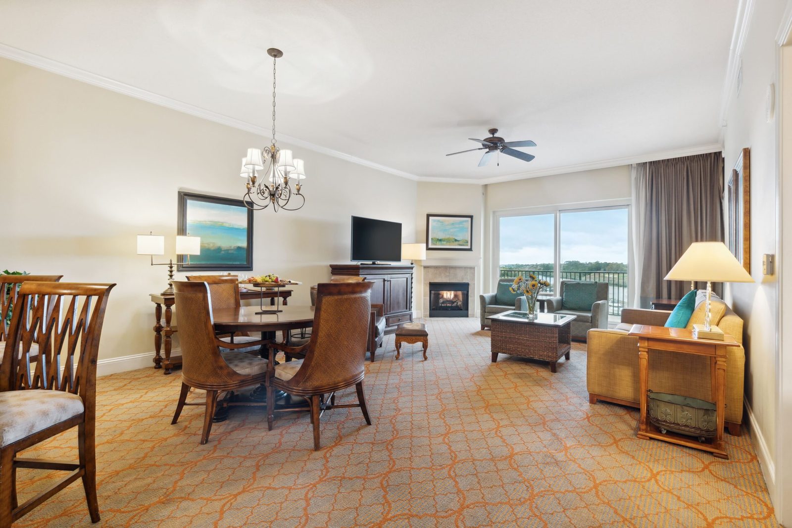Living area of a suite at the Marina Inn, with a fireplace, dining table and a balcony over the water