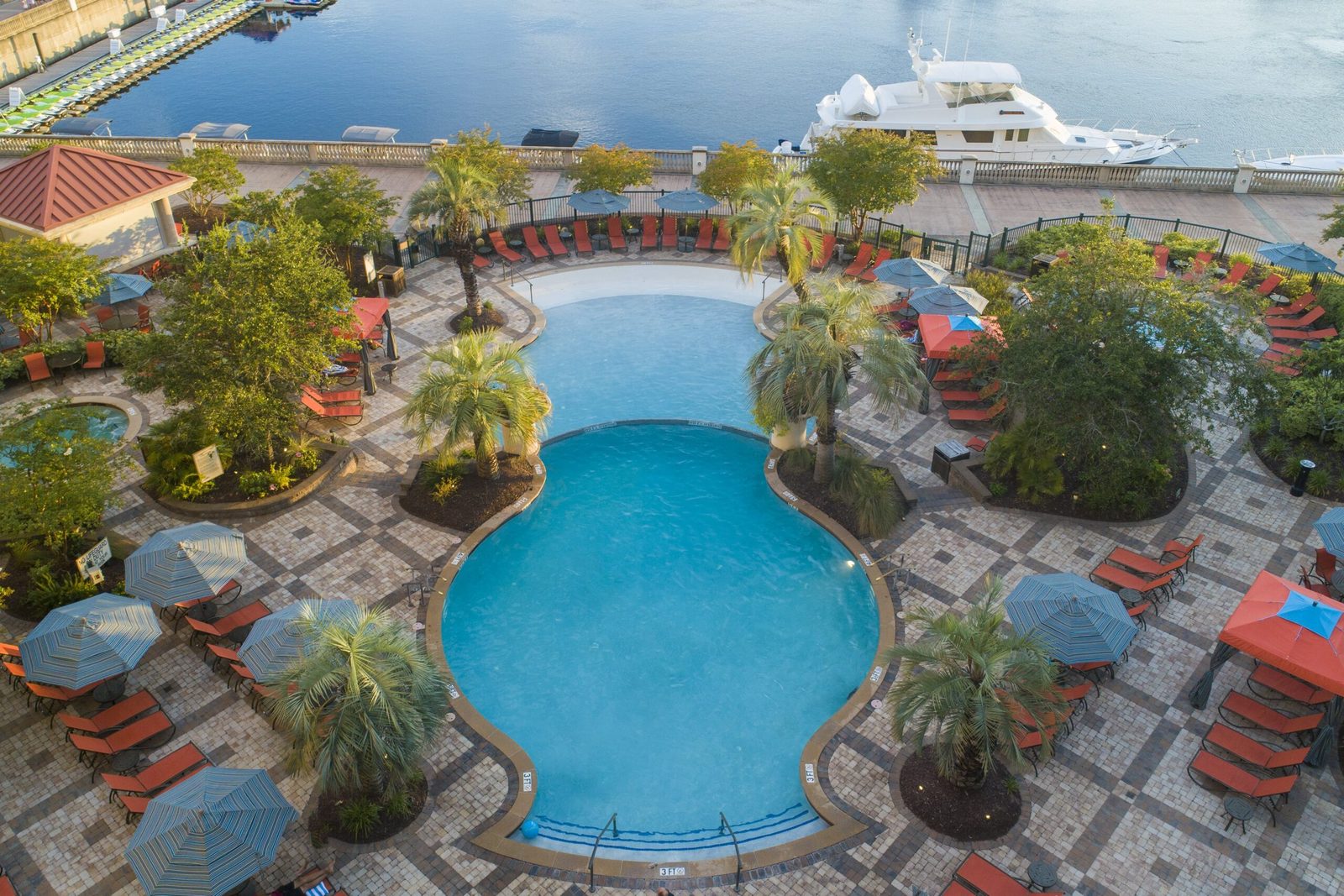 The outdoor pools and sun loungers beside the marina at the Marina Inn