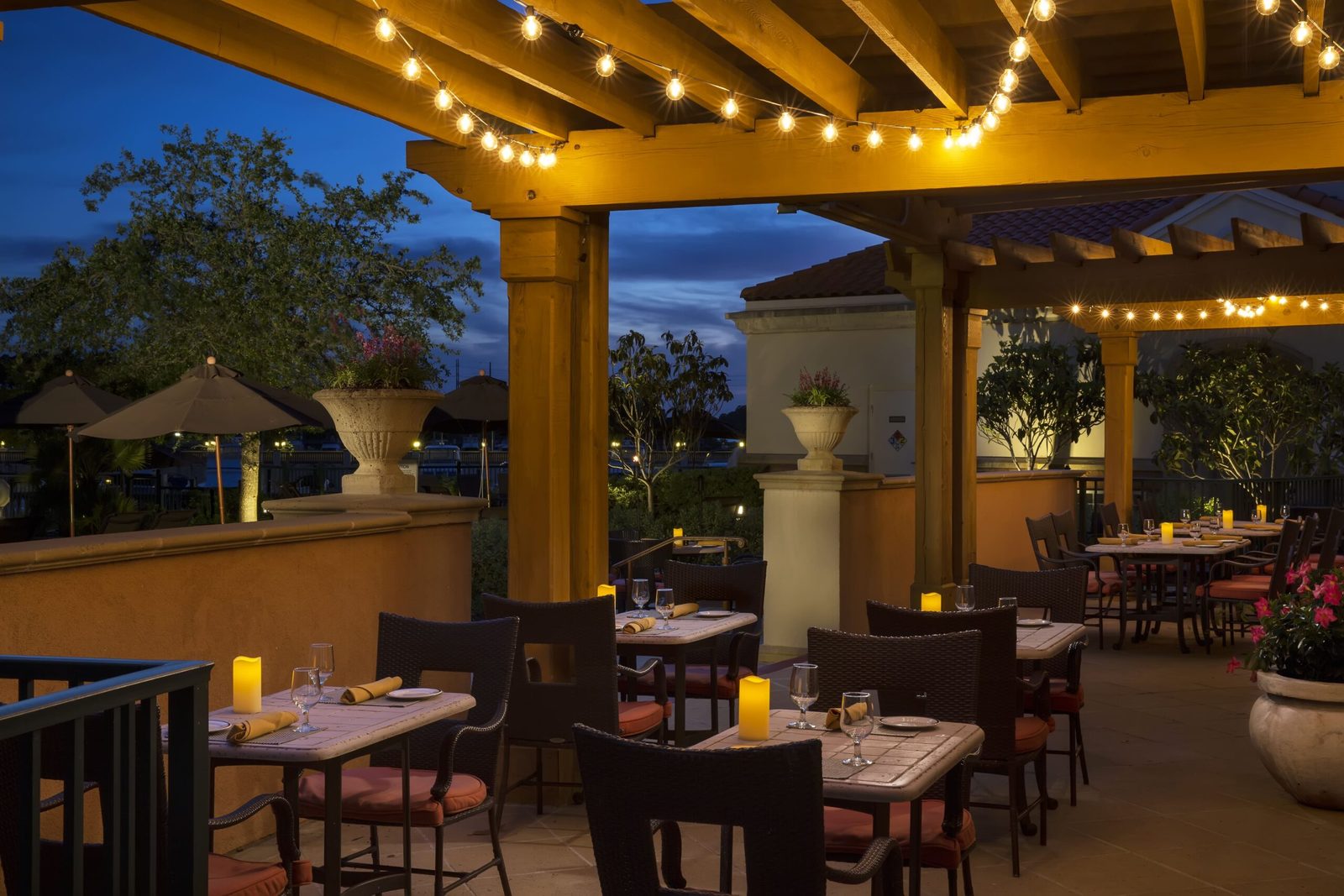 Tables under the lights on the WaterScapes patio at the Marina Inn at dusk