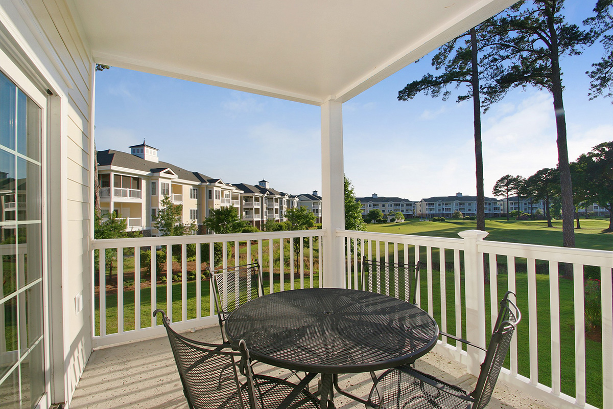 The view over the fairways from a villa balcony at Myrtlewood, with a table set for four