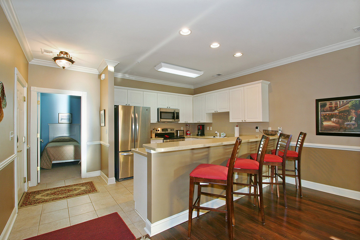 Villa kitchen at Myrtlewood with a breakfast bar, full appliances and a bedroom beyond