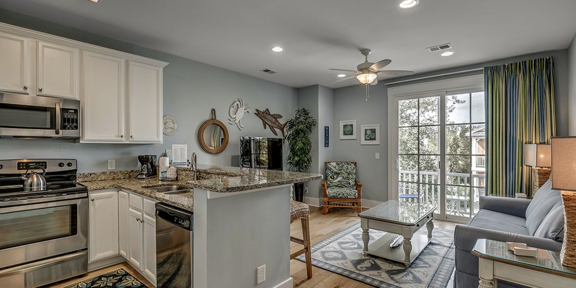 Kitchen and living room of a condo at North Beach Plantation with a balcony beyond the doors