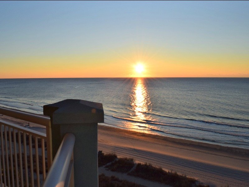 Sunrise over the ocean from a condo balcony at Ocean Blue Resort