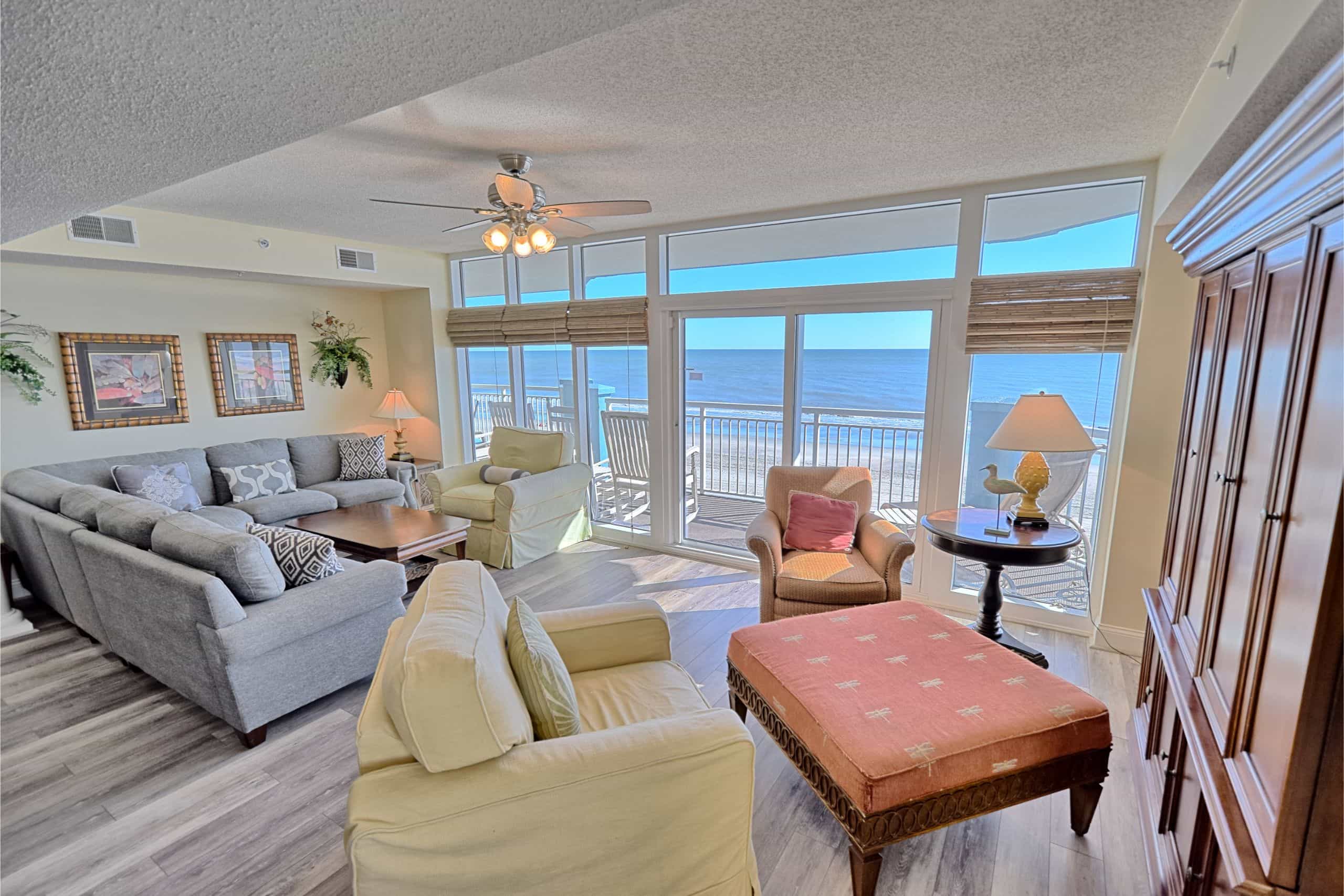 Living area of an oceanfront condo at Ocean Blue Resort, with windows and a balcony onto the water