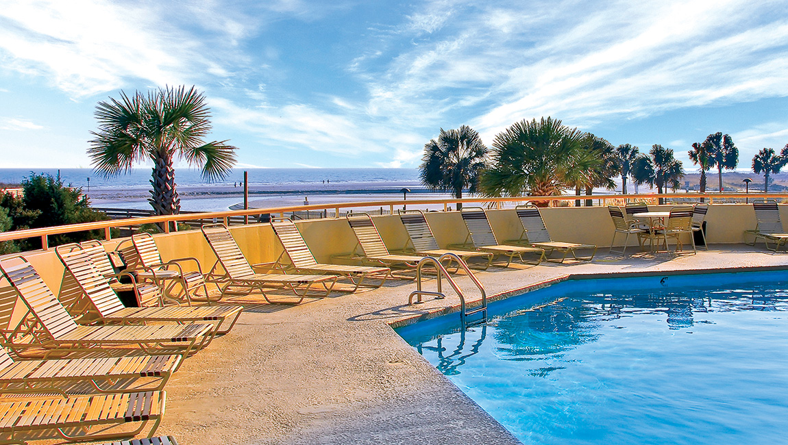 The oceanfront pool and sun loungers looking out to the beach at Ocean Creek Resort