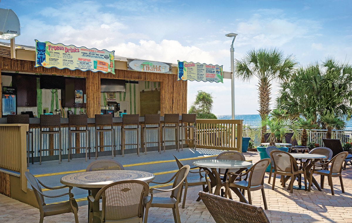 The Tiki Hut bar and its patio tables on the pool deck at Paradise Resort