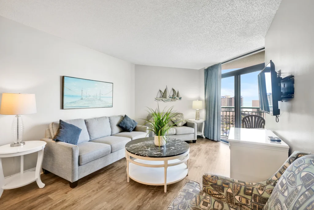 Living area of a condo at Sand Dunes Resort, with sofas and a balcony onto the beachfront
