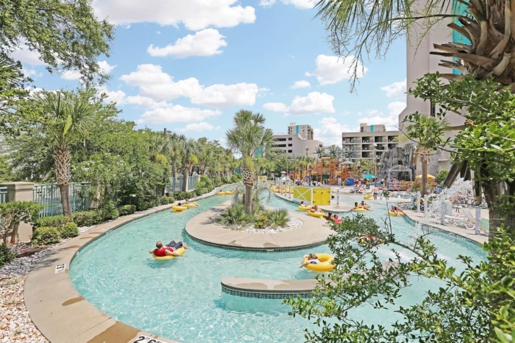 The lazy river winding past the palms at Sand Dunes Resort