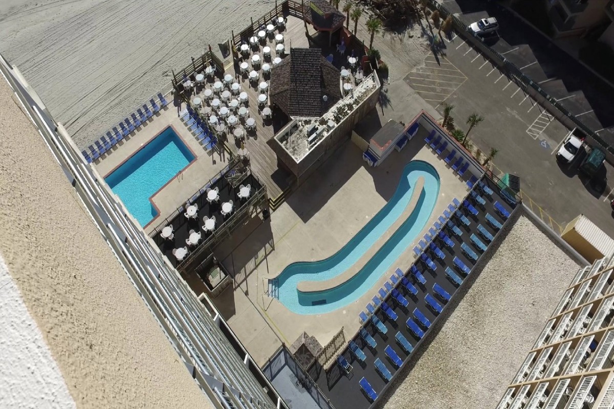 The pool deck and lazy river at Sands Ocean Club from above, with the beach beyond