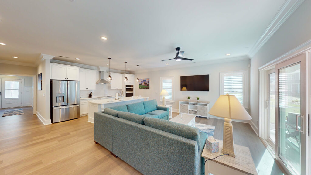 Open living area and kitchen inside a villa at Sea Trail, with doors onto the porch