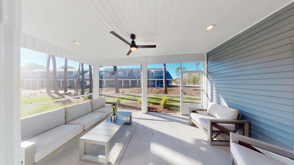The screened porch of a villa at Sea Trail, looking across the lawn to the buildings opposite