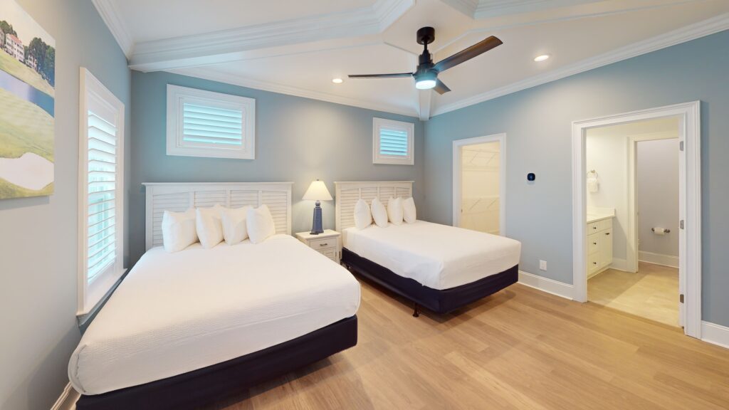 Bedroom with two beds in a villa at Sea Trail, with the bathroom through the door