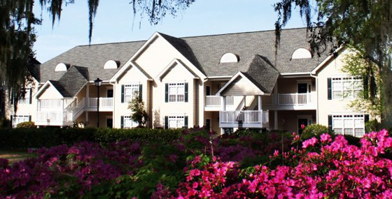 A villa building at Village at the Glens behind a bank of flowering azaleas