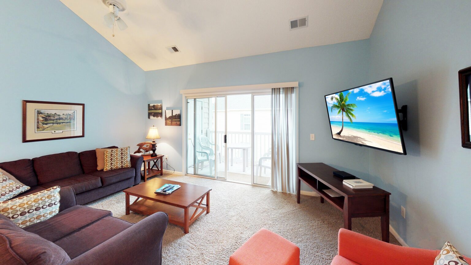 Living area of a villa at Village at the Glens, with sliding doors onto the balcony