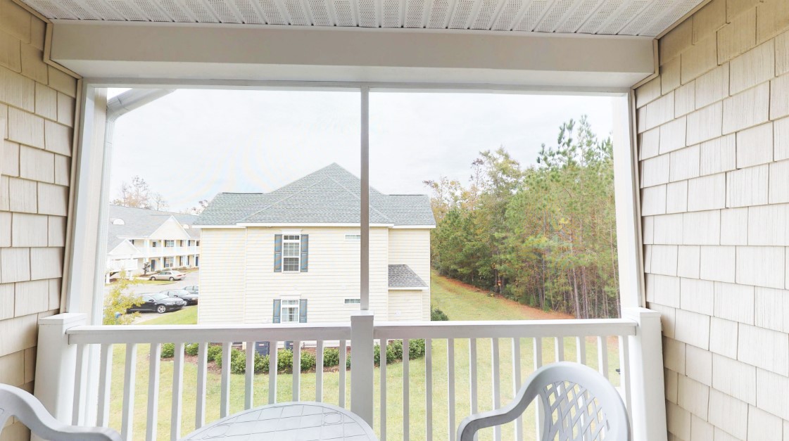 The screened balcony of a villa at Village at the Glens looking across the community