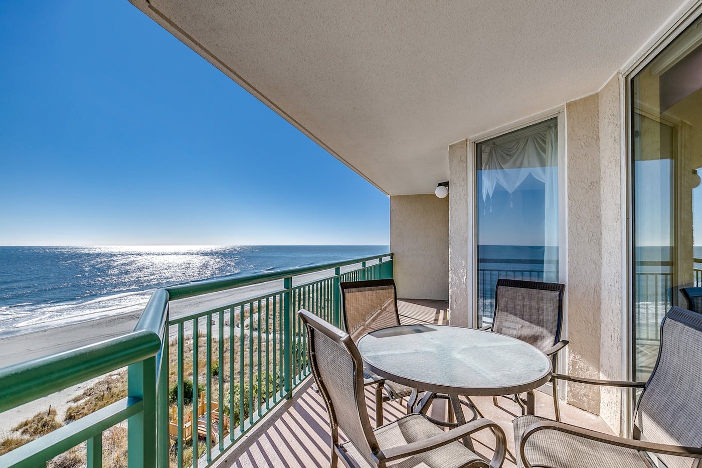 The balcony of a condo at Windy Hill Dunes, looking down the beach